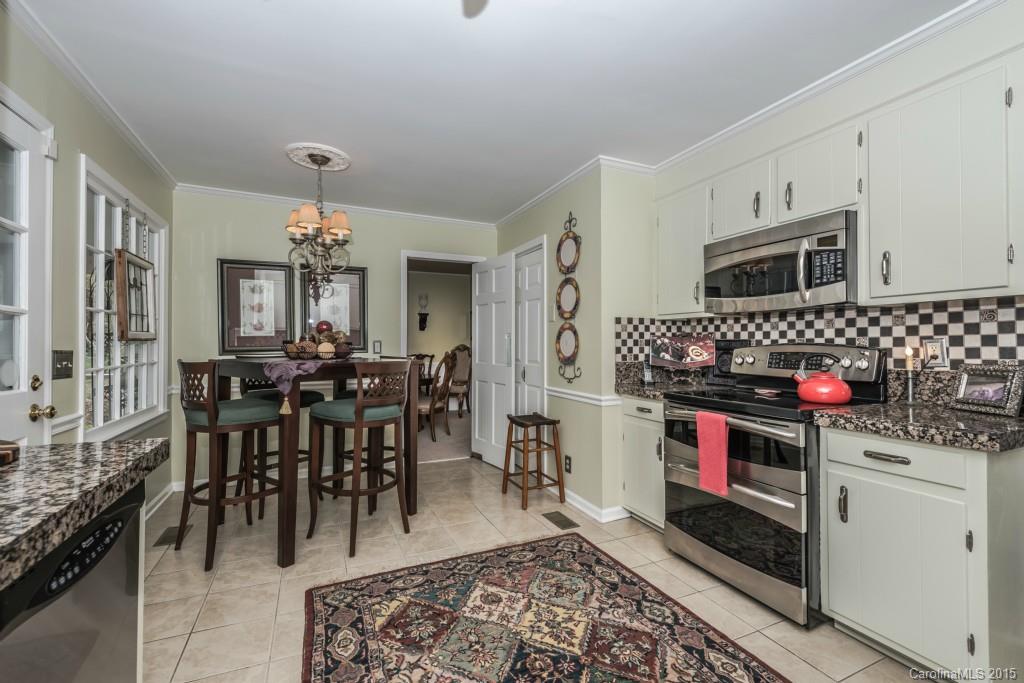 6737 Harrison Road Charlotte, NC 28270 - Photo 7 of 23 a kitchen with stainless steel appliances granite countertop a stove top oven a sink a dining table and chairs