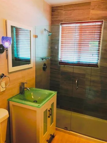a bathroom with a granite countertop sink and a bathtub
