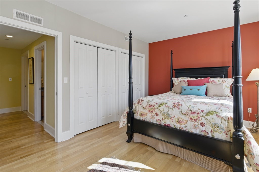 2 Powder Mill Square, Unit 2B Andover, MA 01810 - Photo 14 of 31 a bedroom with a bed and wooden floor