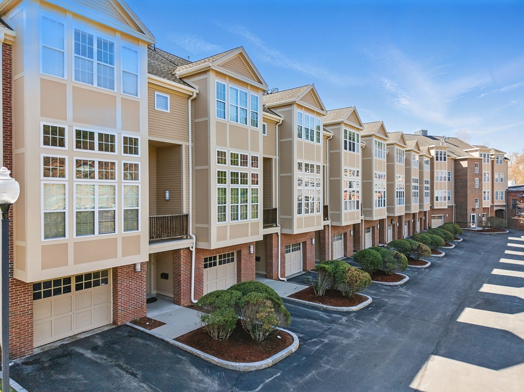 2 Powder Mill Square, Unit 2B Andover, MA 01810 - Photo 27 of 31 a front view of a building with balcony and garden