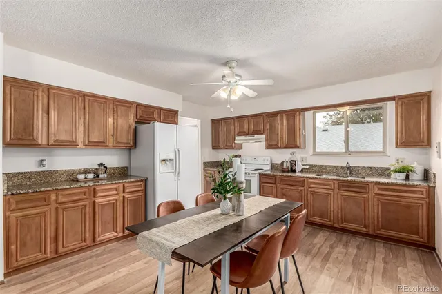 a kitchen with stainless steel appliances granite countertop a stove a sink dishwasher a stove a refrigerator with a dining table and chairs