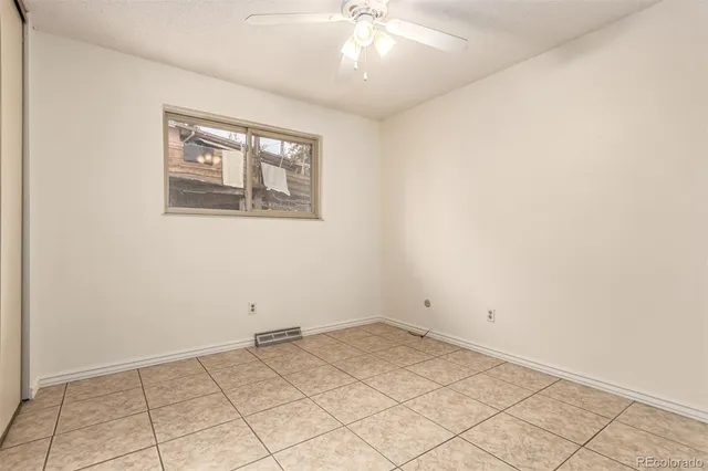 an empty room with a chandelier fan