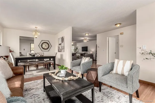 a living room with furniture kitchen view and a window