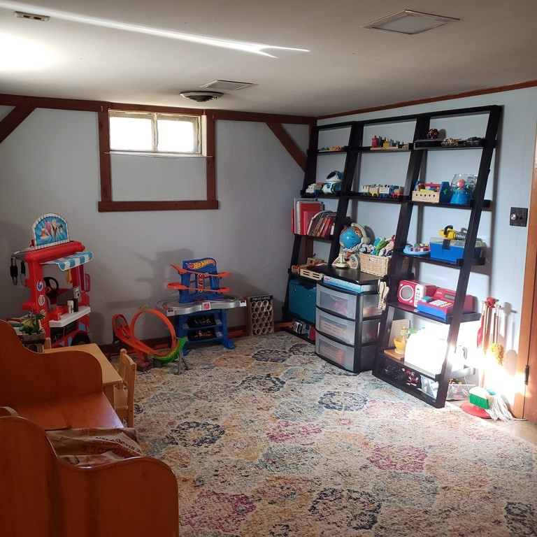258 Cooper Street Springfield, MA 01108 - Photo 23 of 28 a bedroom with furniture a rug and a bookshelf