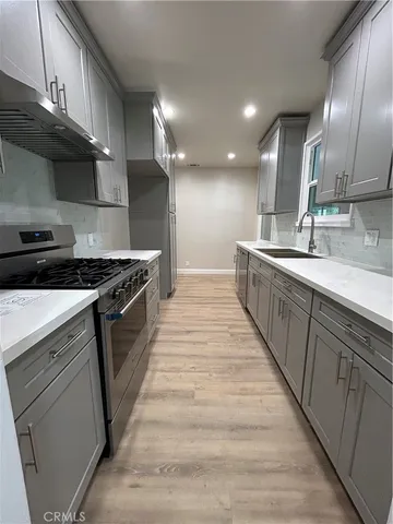 a large kitchen with stainless steel appliances granite countertop a stove a sink and a refrigerator