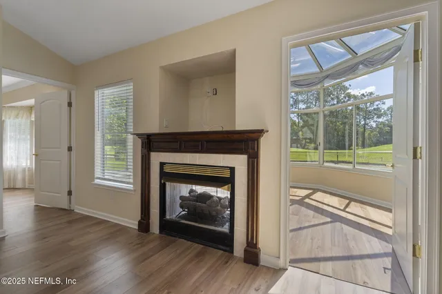 a view of a livingroom with a fireplace and window