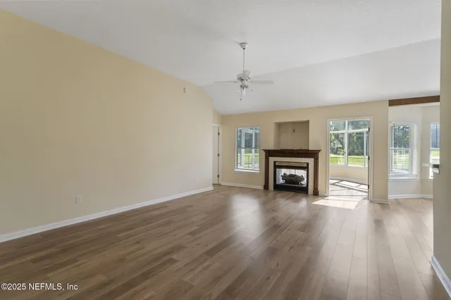 a view of a livingroom with wooden floor and a ceiling fan