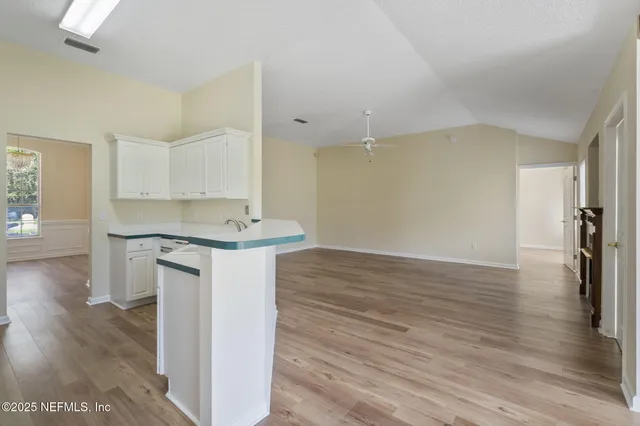 a kitchen with a refrigerator and a wooden floor