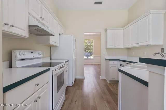 a kitchen with a stove sink and cabinets