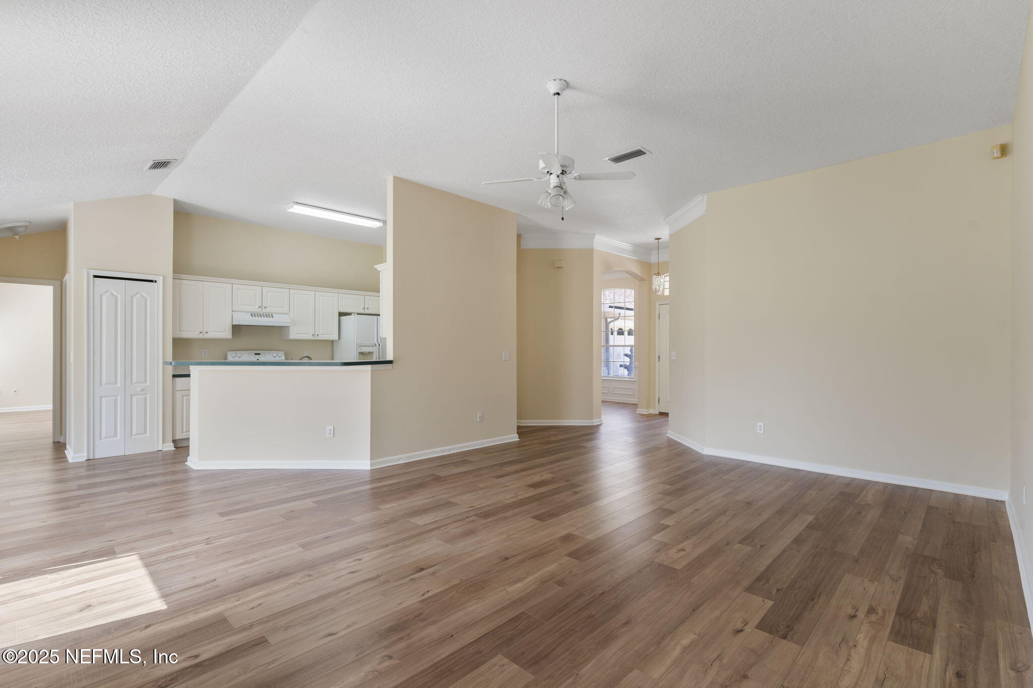 5673 Piper Glen Boulevard Jacksonville, FL 32222 - Photo 23 of 45 a view of an empty room and kitchen with wooden floor