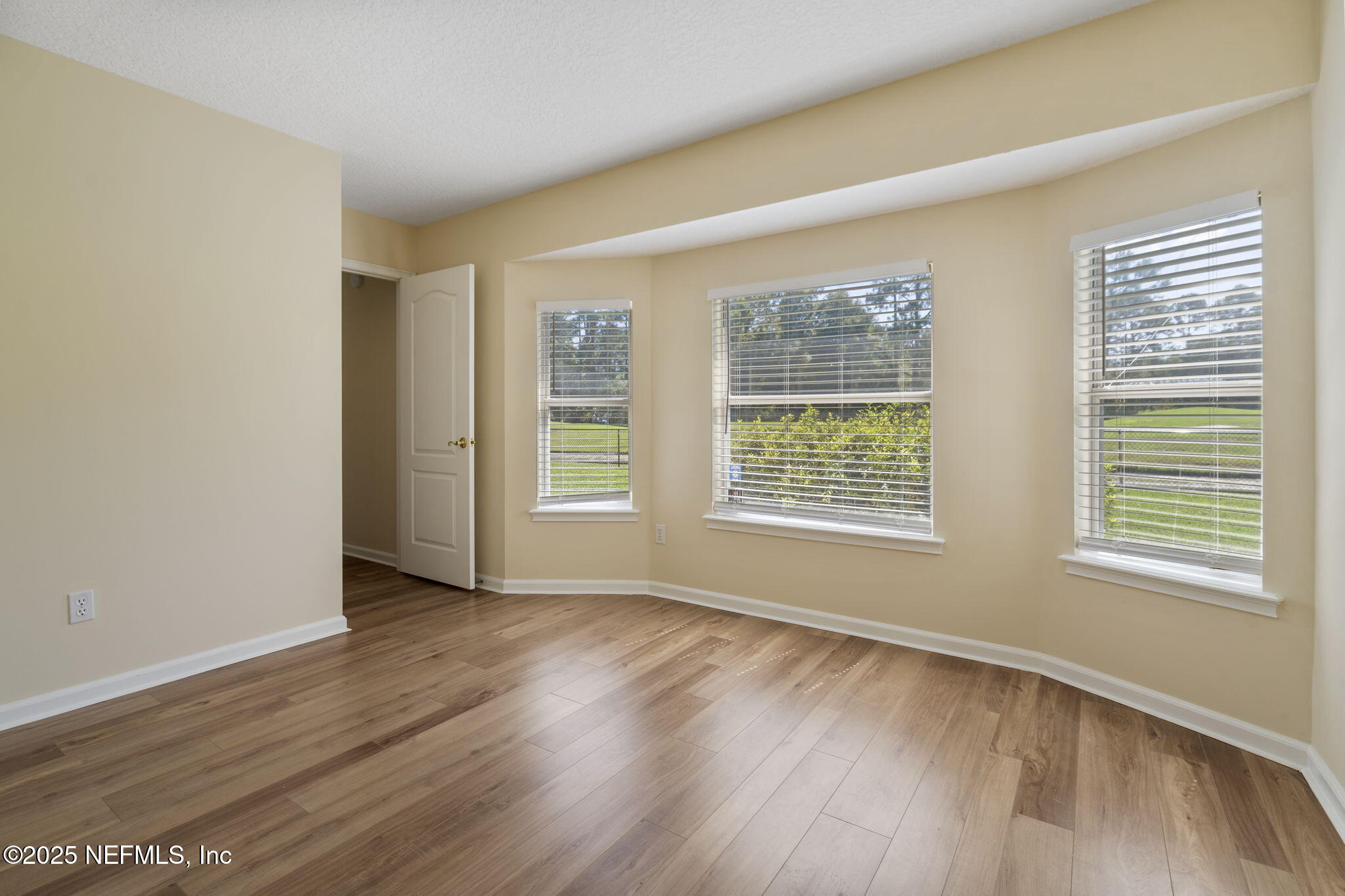 5673 Piper Glen Boulevard Jacksonville, FL 32222 - Photo 28 of 45 a view of an empty room with wooden floor and a window