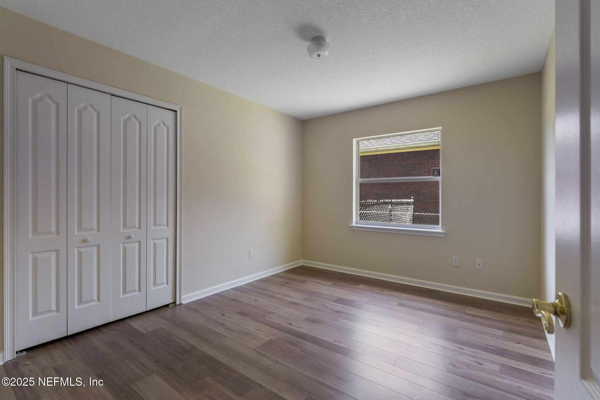 5673 Piper Glen Boulevard Jacksonville, FL 32222 - Photo 31 of 45 a view of an empty room with wooden floor and a window