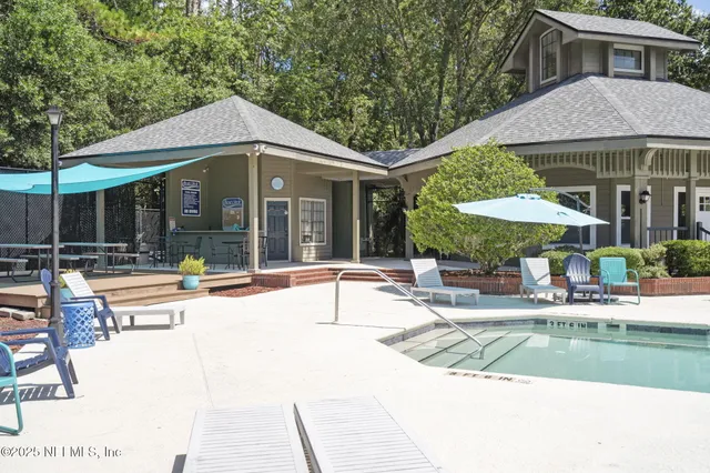 a patio area with table and chairs under an umbrella
