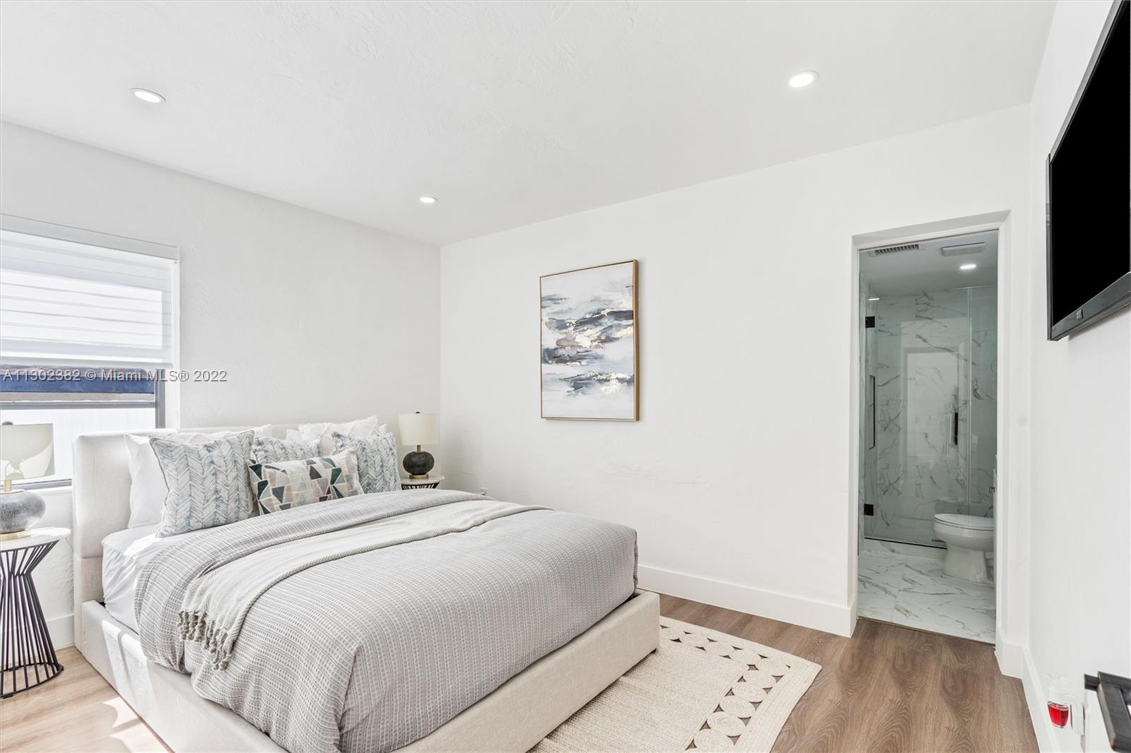 450 Flagami Boulevard Miami, FL 33144 - Photo 13 of 23 a bedroom with a bed and a flat screen tv