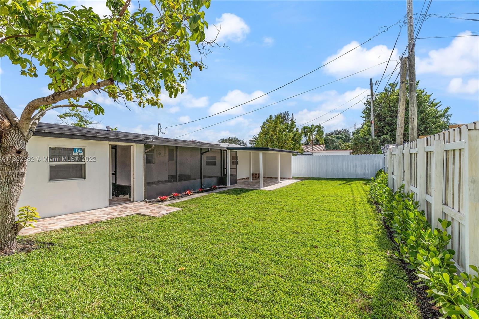450 Flagami Boulevard Miami, FL 33144 - Photo 23 of 23 a view of a backyard with table and chairs and wooden fence