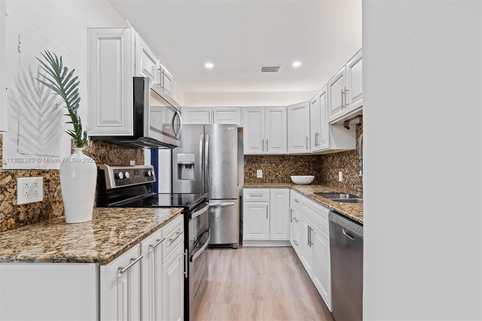 450 Flagami Boulevard Miami, FL 33144 - Photo 7 of 23 a kitchen with stainless steel appliances granite countertop a stove a sink and a refrigerator