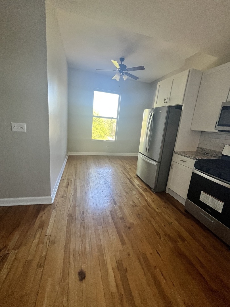 501 West 60th Place, Unit 3 Chicago, IL 60621 - Photo 5 of 12 wooden floor in an empty room with a window