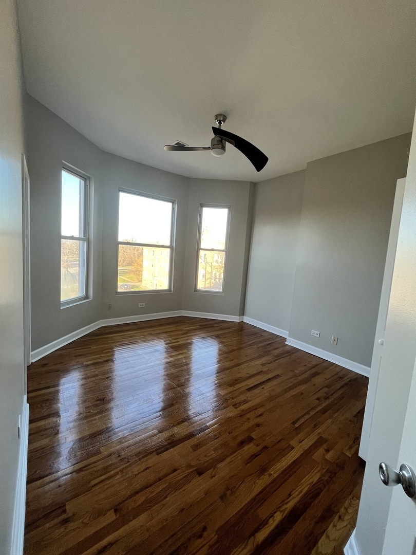 501 West 60th Place, Unit 3 Chicago, IL 60621 - Photo 7 of 12 a view of empty room with wooden floor and fan
