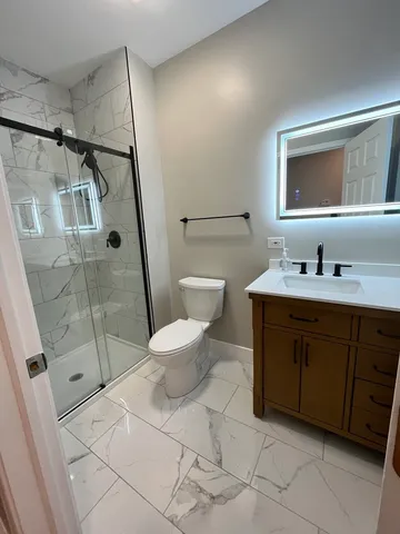 a spacious bathroom with a double vanity sink toilet and shower