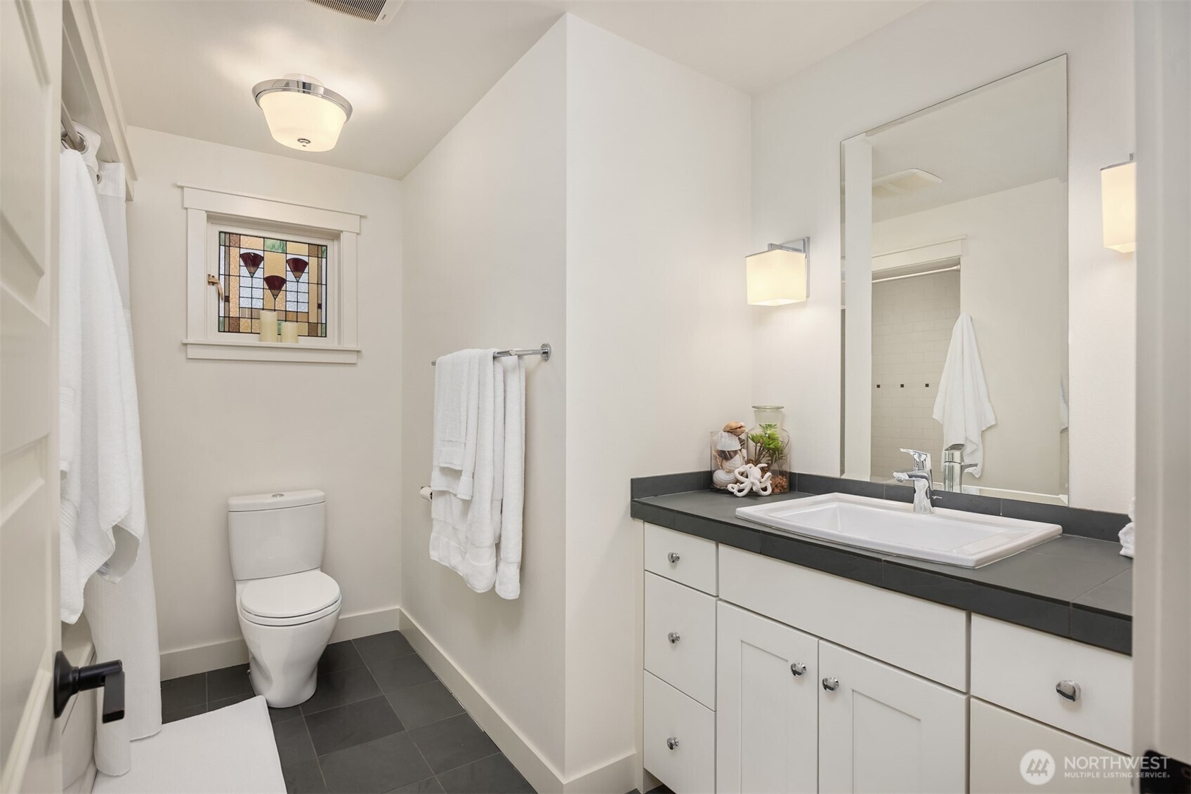 7204 Northeast Baker Hill Road Bainbridge Island, WA 98110 - Photo 24 of 40 a bathroom with a toilet a sink and a mirror