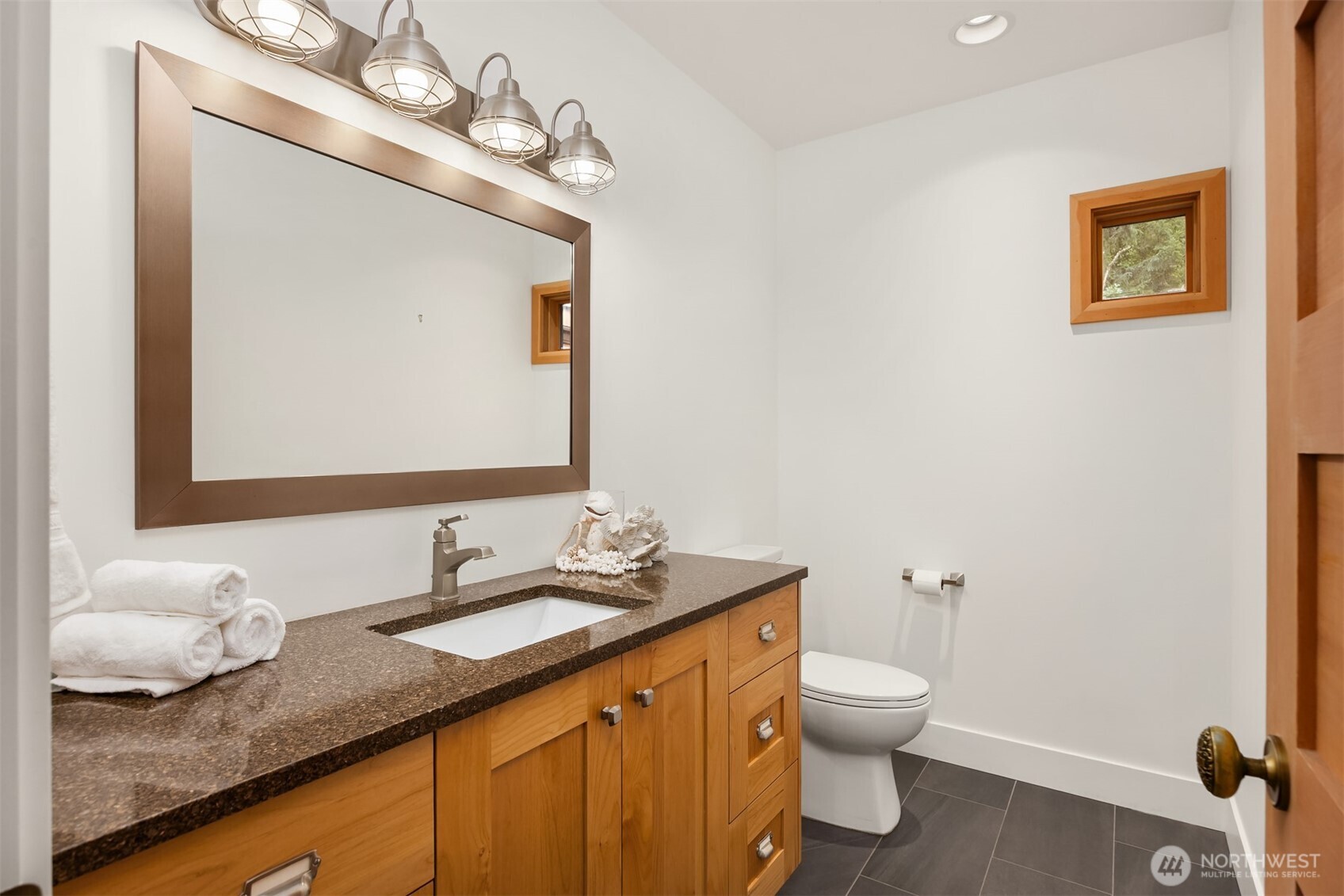 7204 Northeast Baker Hill Road Bainbridge Island, WA 98110 - Photo 34 of 40 a bathroom with a granite countertop sink a toilet and a mirror
