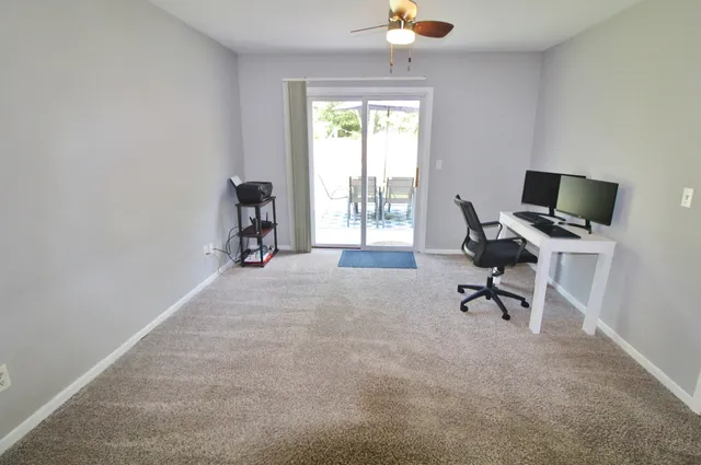 a view of a workspace with furniture and a window