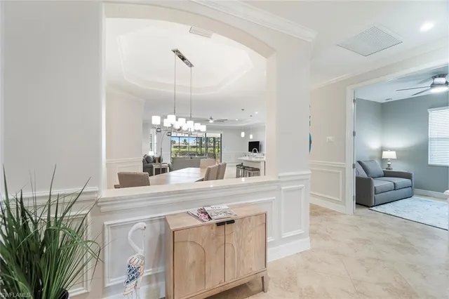 a large white kitchen with kitchen island white cabinets and stainless steel appliances