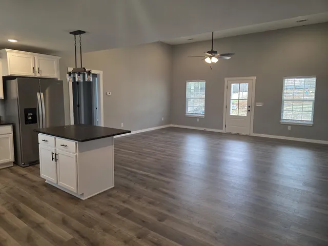 a kitchen with stainless steel appliances granite countertop a refrigerator a stove and a wooden floors