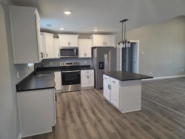 a kitchen with stainless steel appliances granite countertop a stove a refrigerator and a microwave