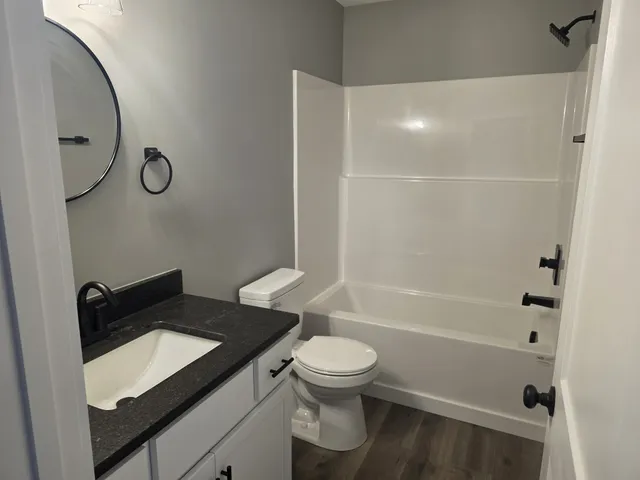 a bathroom with a granite countertop sink toilet and shower