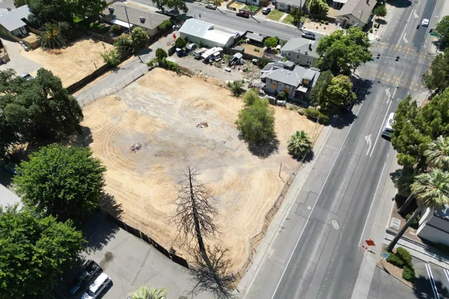 an aerial view of a house with a yard and mountain view in back