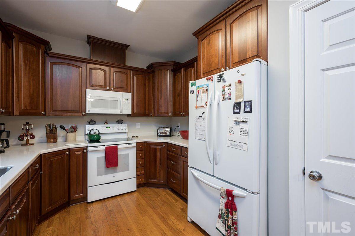 5704 Dunstan Court Raleigh, NC 27613 - Photo 11 of 23 a kitchen with granite countertop a refrigerator a sink dishwasher a stove top oven a refrigerator and cabinets with wooden floor