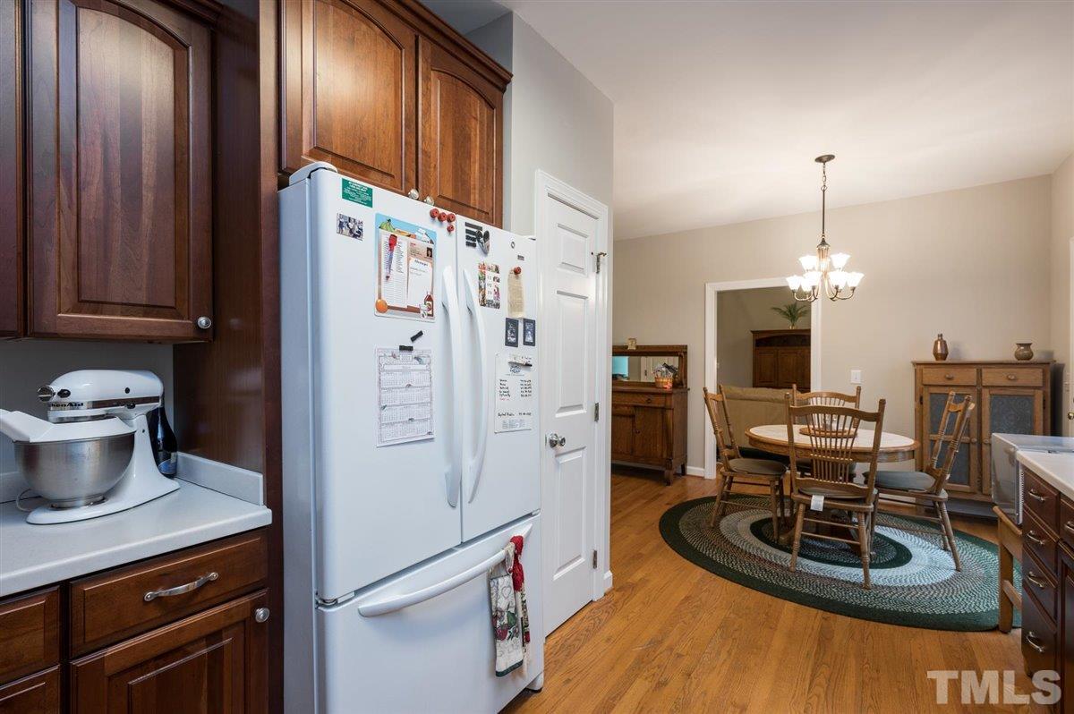 5704 Dunstan Court Raleigh, NC 27613 - Photo 13 of 23 a kitchen with stainless steel appliances granite countertop a refrigerator a stove and a wooden floors