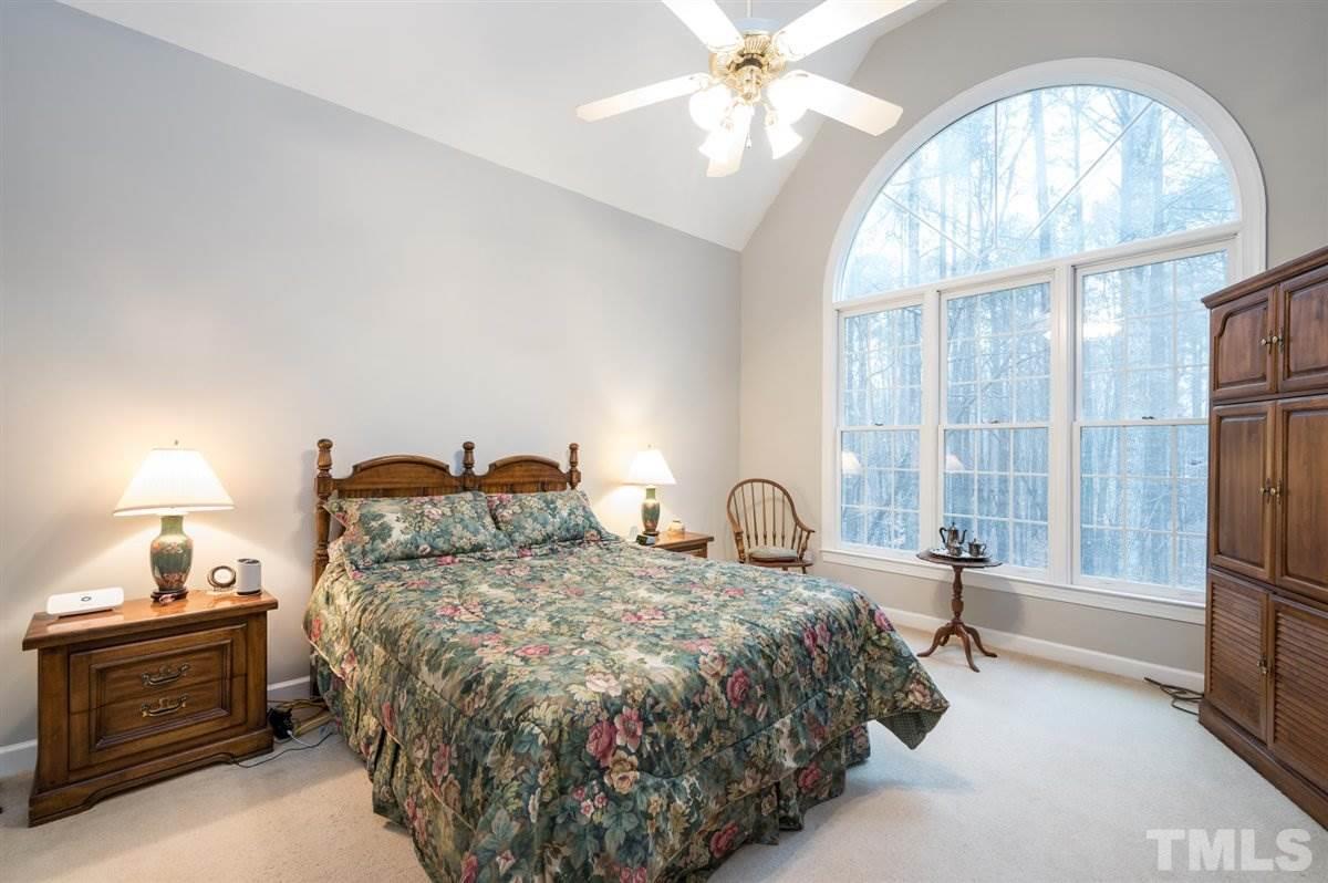 5704 Dunstan Court Raleigh, NC 27613 - Photo 7 of 23 a bedroom with a bed and a chandelier