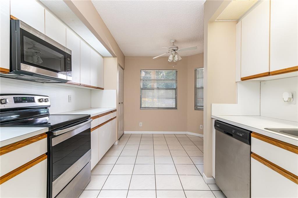 1601 Abaco Drive, Unit D1 Coconut Creek, FL 33066 - Photo 3 of 25 a kitchen with stainless steel appliances granite countertop a sink and a stove