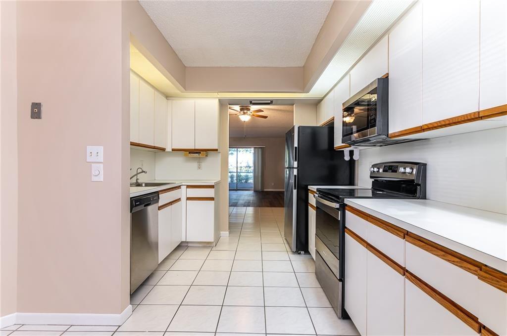 1601 Abaco Drive, Unit D1 Coconut Creek, FL 33066 - Photo 4 of 25 a kitchen with stainless steel appliances granite countertop a refrigerator and a stove top oven