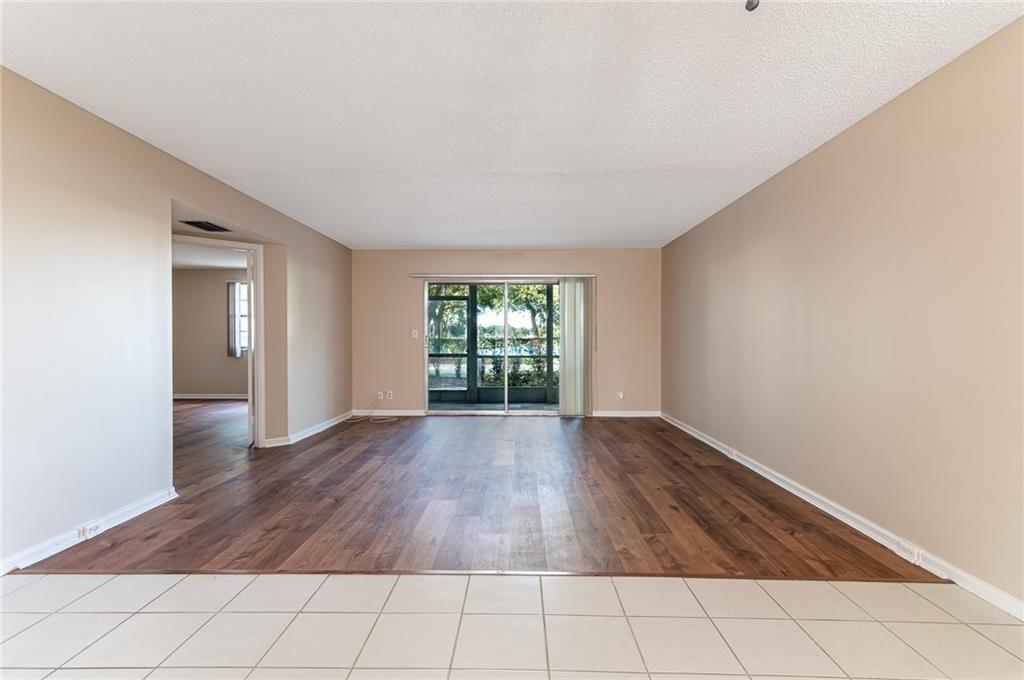 1601 Abaco Drive, Unit D1 Coconut Creek, FL 33066 - Photo 5 of 25 wooden floor in an empty room with a window