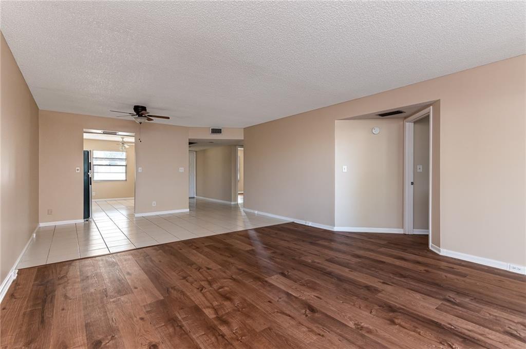 1601 Abaco Drive, Unit D1 Coconut Creek, FL 33066 - Photo 6 of 25 a view of empty room with wooden floor and fan