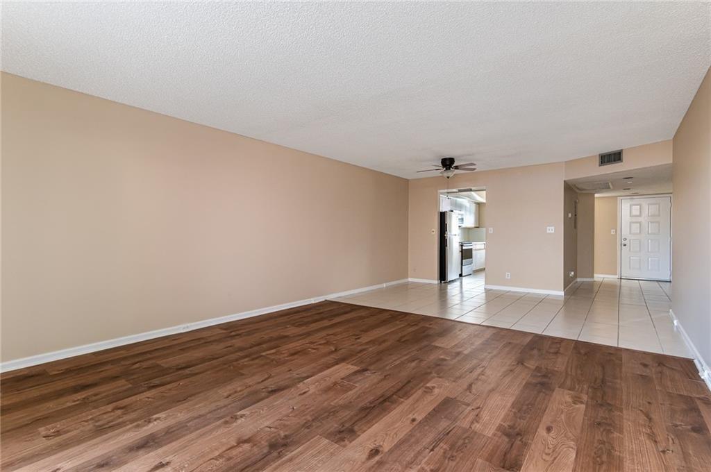 1601 Abaco Drive, Unit D1 Coconut Creek, FL 33066 - Photo 7 of 25 wooden floor in an empty room with a window