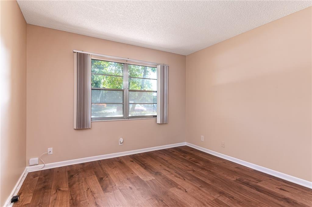 1601 Abaco Drive, Unit D1 Coconut Creek, FL 33066 - Photo 8 of 25 a view of an empty room with wooden floor and a window