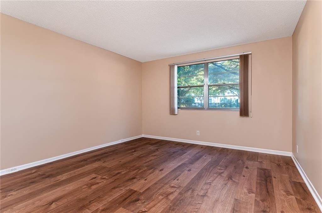 1601 Abaco Drive, Unit D1 Coconut Creek, FL 33066 - Photo 10 of 25 a view of an empty room with wooden floor and a window