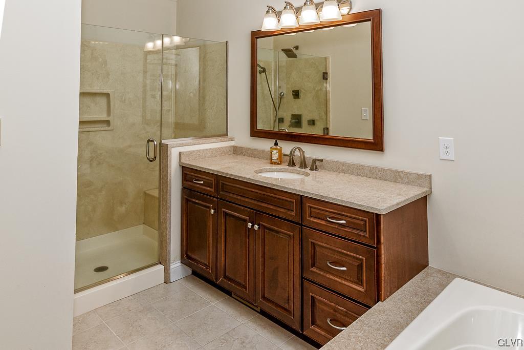973 Renaldi Road Wind Gap, PA 18091 - Photo 23 of 50 a bathroom with a granite countertop sink a mirror and a shower