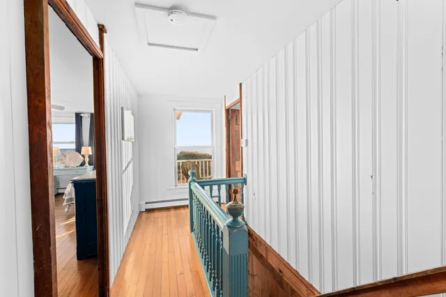 a view of a hallway with wooden floor and staircase