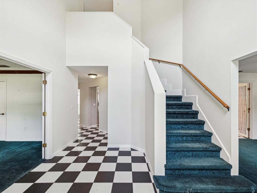 15420 Aubrey Avenue Spring Hill, FL 34610 - Photo 6 of 28 a view of a hallway with a black and white checkered floor