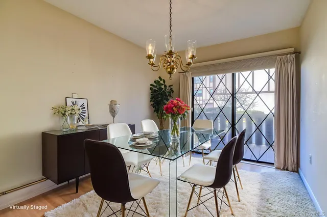 a dining room with furniture potted plants and wooden floor
