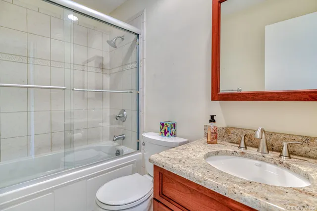 a bathroom with a granite countertop sink toilet and shower