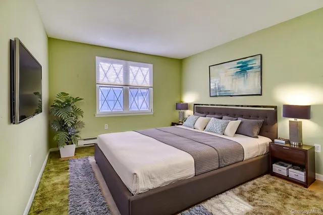 a bedroom with a bed and a painting on the wall