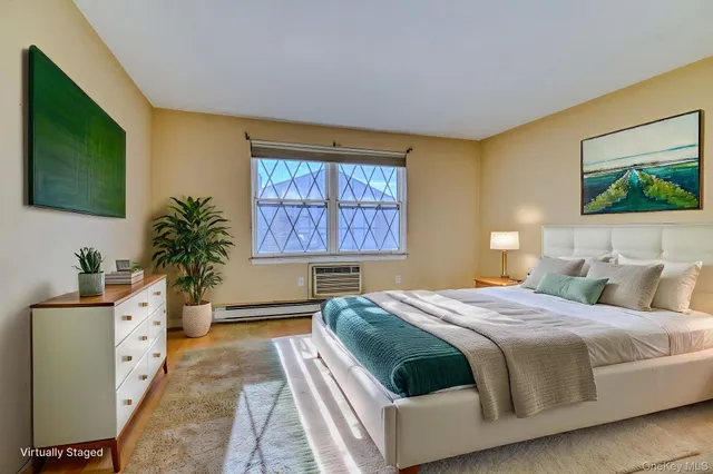 a bedroom with a bed a window dresser and flat screen tv