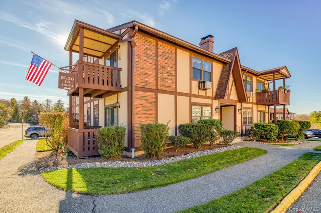 a front view of a multi story residential apartment building with yard