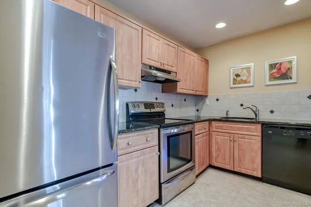 a kitchen with stainless steel appliances granite countertop a stove sink and cabinets